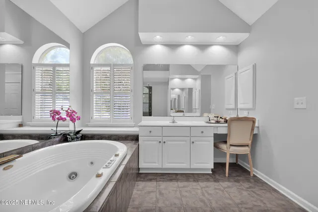 a bathroom with a tub sink and mirror