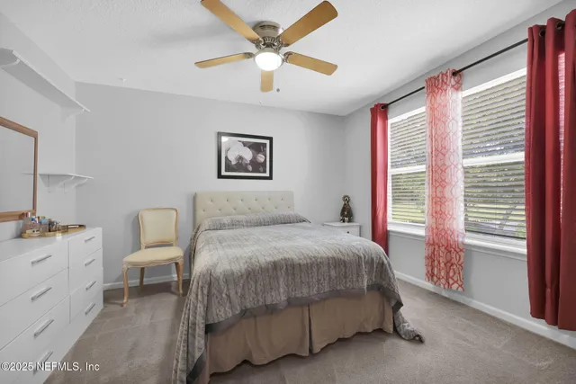 a bedroom with a bed a chandelier and a window