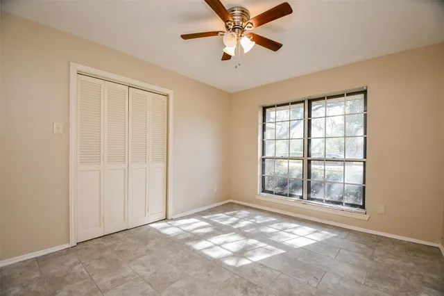 an empty room with chandelier fan