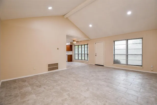 a view of empty room with a kitchen