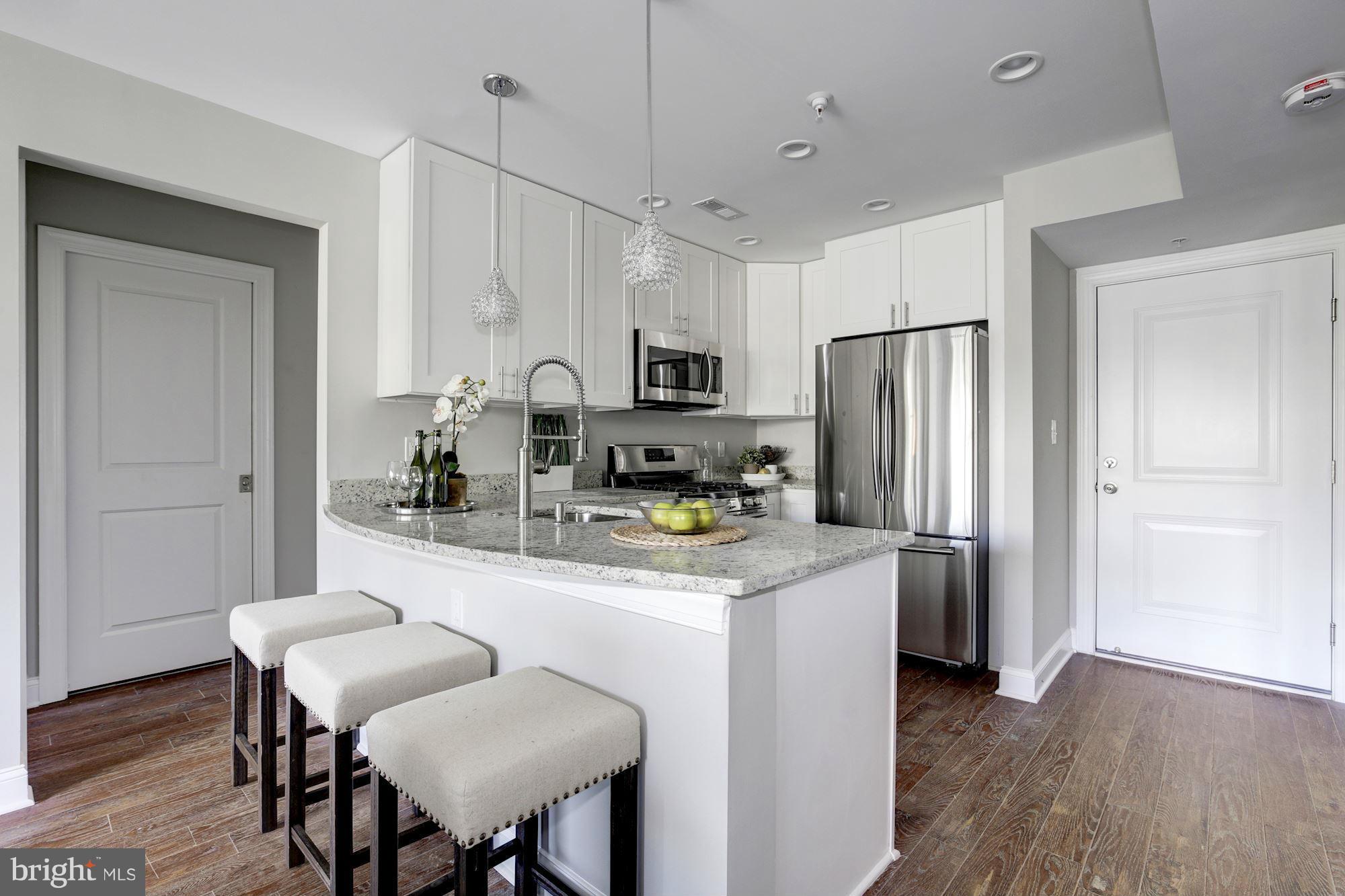 1920 3rd Street Northeast, Unit 7 Washington, DC 20002 - Photo 3 of 21 a kitchen with stainless steel appliances granite countertop a refrigerator a stove a sink dishwasher and a refrigerator with wooden floor