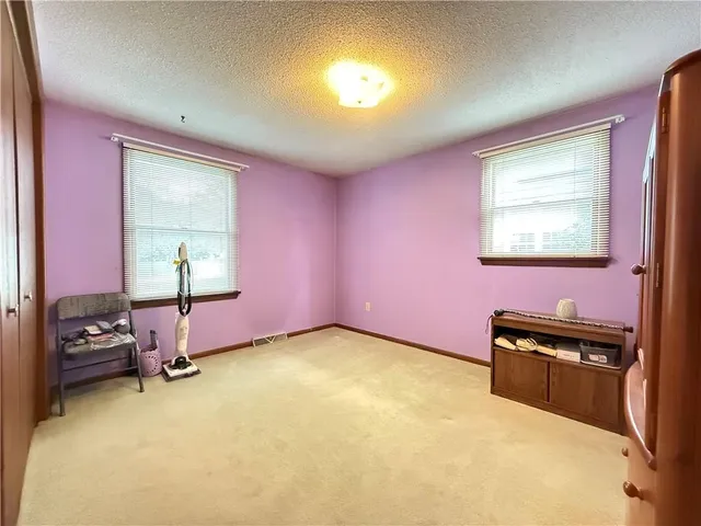 a bedroom with a bed dresser and a window