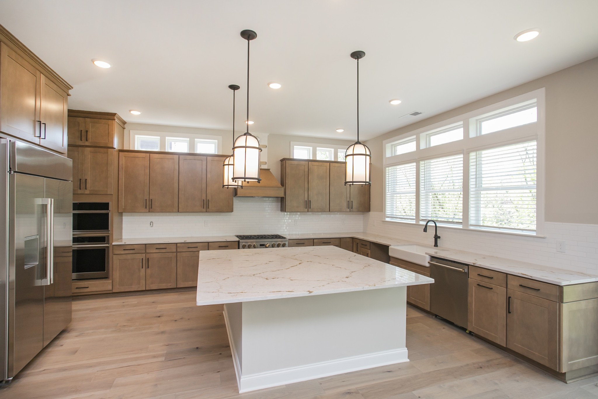 5956 Hunt Vly Drive Spring Hill, TN 37174 - Photo 19 of 53 a view of a kitchen with kitchen island a sink appliances wooden floor and a counter top space