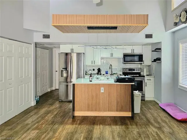 a kitchen with stainless steel appliances granite countertop a refrigerator and a stove top oven