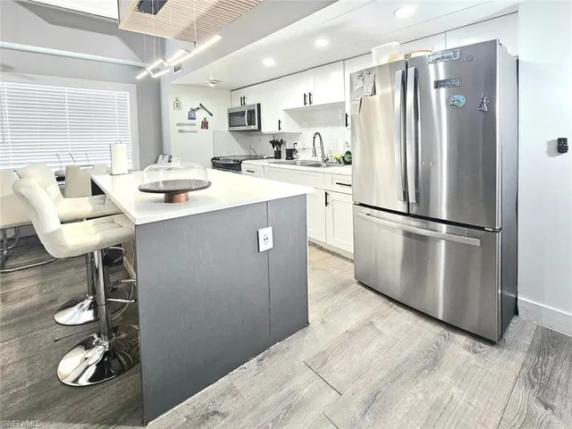 a kitchen with refrigerator and chairs