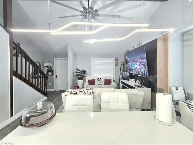 a living room with furniture a flat screen tv and a wall painting