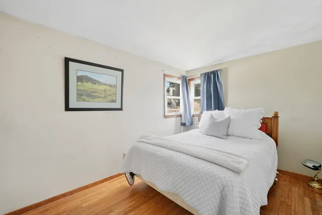 a bedroom with a bed and a painting on the wall