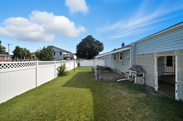 a backyard of a house with table and chairs