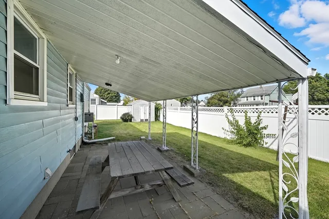 a view of backyard with table and chairs potted plants with floor to ceiling window