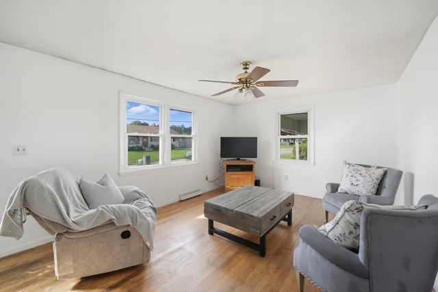 a living room with furniture a flat screen tv and a large window