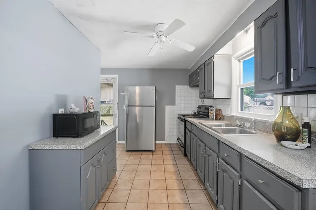 a kitchen with a refrigerator sink and wooden cabinets