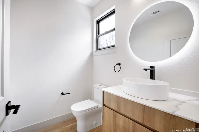 a bathroom with a sink mirror and toilet