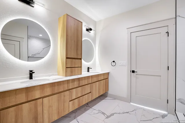 a en suite bathroom with a double vanity sink and a mirror