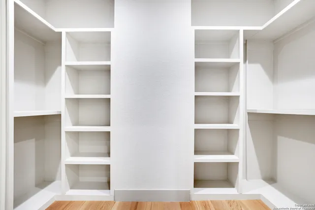 a view of walk in closet with empty racks