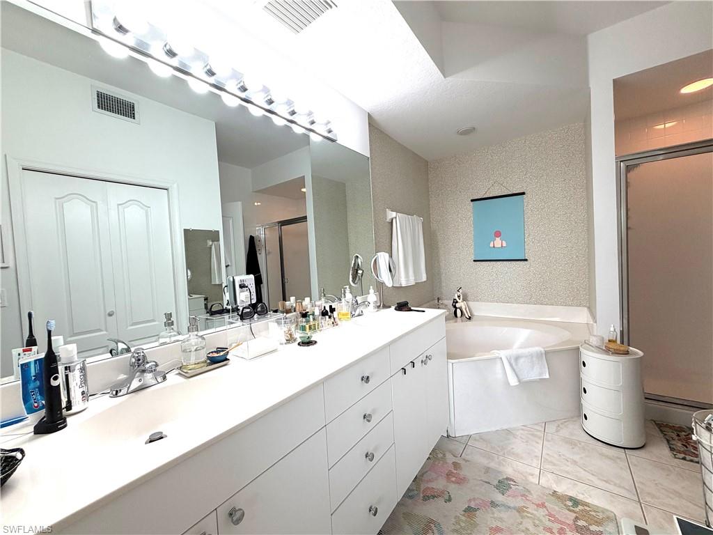 2377 Ravenna Boulevard, Unit 101 Naples, FL 34109 - Photo 14 of 19 a bathroom with a double vanity sink toilet and a mirror