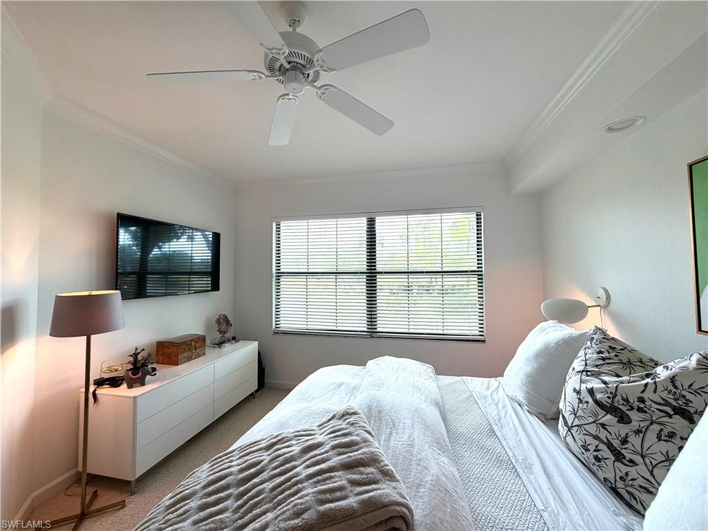 2377 Ravenna Boulevard, Unit 101 Naples, FL 34109 - Photo 18 of 19 a bedroom with a bed and a flat screen tv