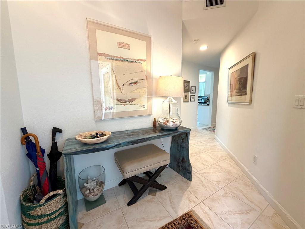 2377 Ravenna Boulevard, Unit 101 Naples, FL 34109 - Photo 19 of 19 a living room with furniture and a mirror