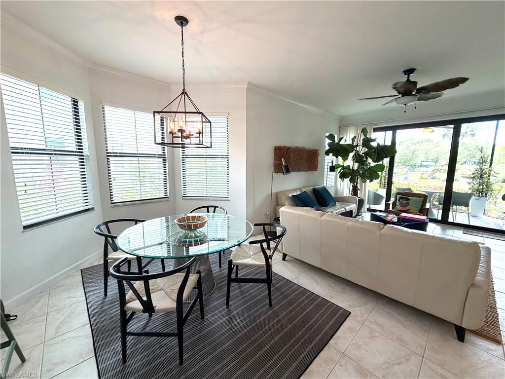 2377 Ravenna Boulevard, Unit 101 Naples, FL 34109 - Photo 4 of 19 a dining room with furniture a chandelier and wooden floor