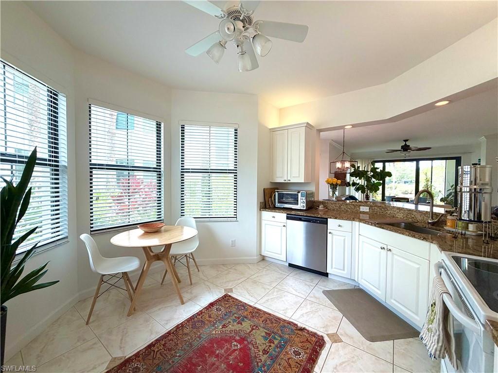2377 Ravenna Boulevard, Unit 101 Naples, FL 34109 - Photo 6 of 19 a large kitchen with a table and chairs in it