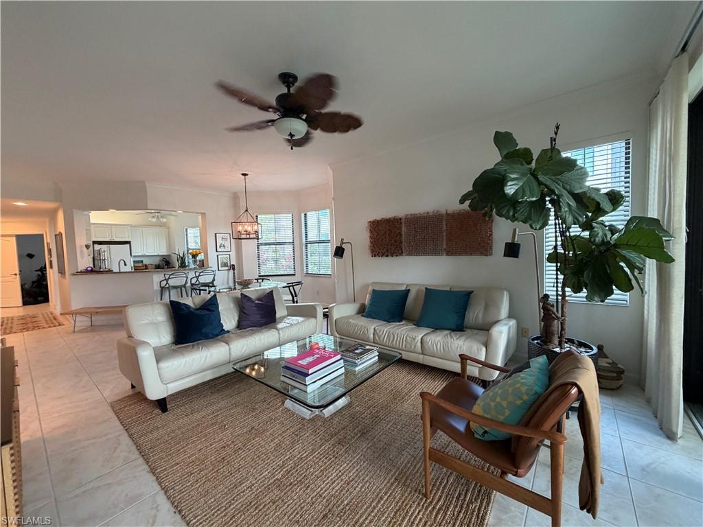 2377 Ravenna Boulevard, Unit 101 Naples, FL 34109 - Photo 7 of 19 a living room with furniture and a potted plant