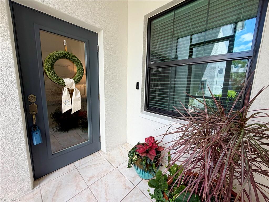 2377 Ravenna Boulevard, Unit 101 Naples, FL 34109 - Photo 10 of 19 a front view of a house with a potted plant