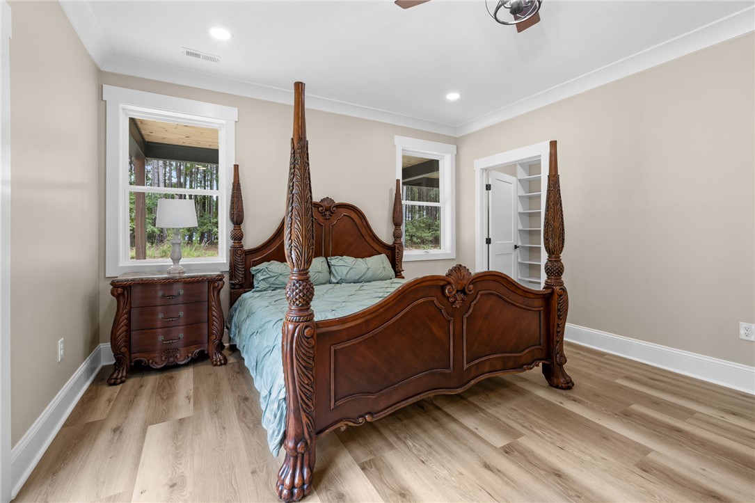 147 McAlister Road West Union, SC 29696 - Photo 17 of 50 Rich wood floors and elegant crown molding elevate this serene bedroom space.