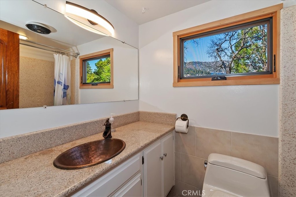 495 Kuffel Canyon Road Lake Arrowhead, CA 92352 - Photo 34 of 64 a bathroom with a sink a toilet and a window