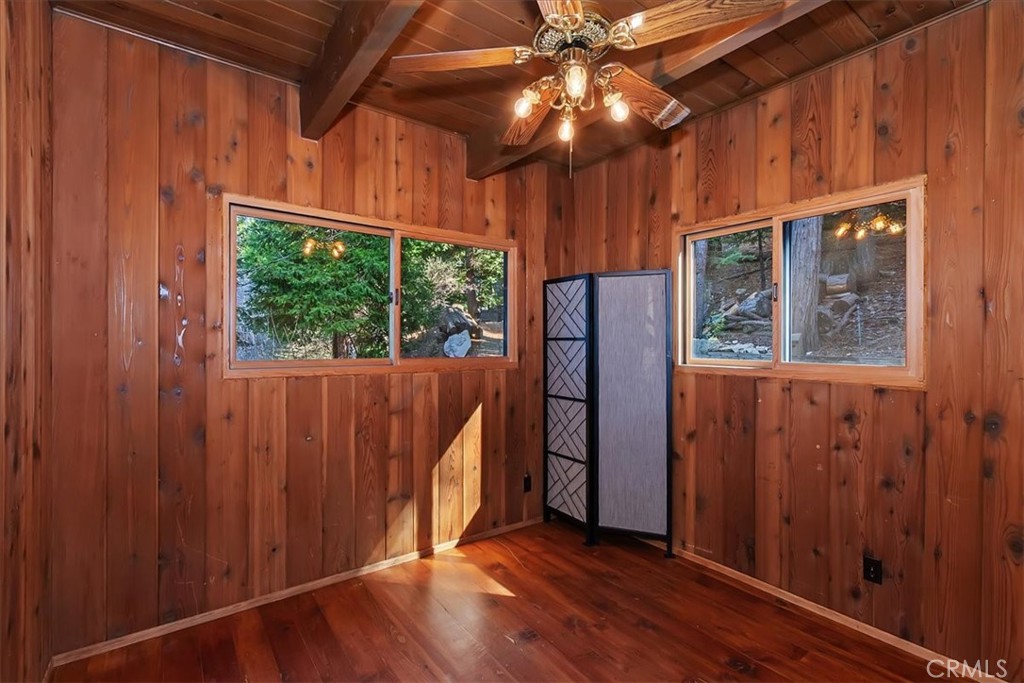 495 Kuffel Canyon Road Lake Arrowhead, CA 92352 - Photo 40 of 64 an empty room with wooden floor fan and windows