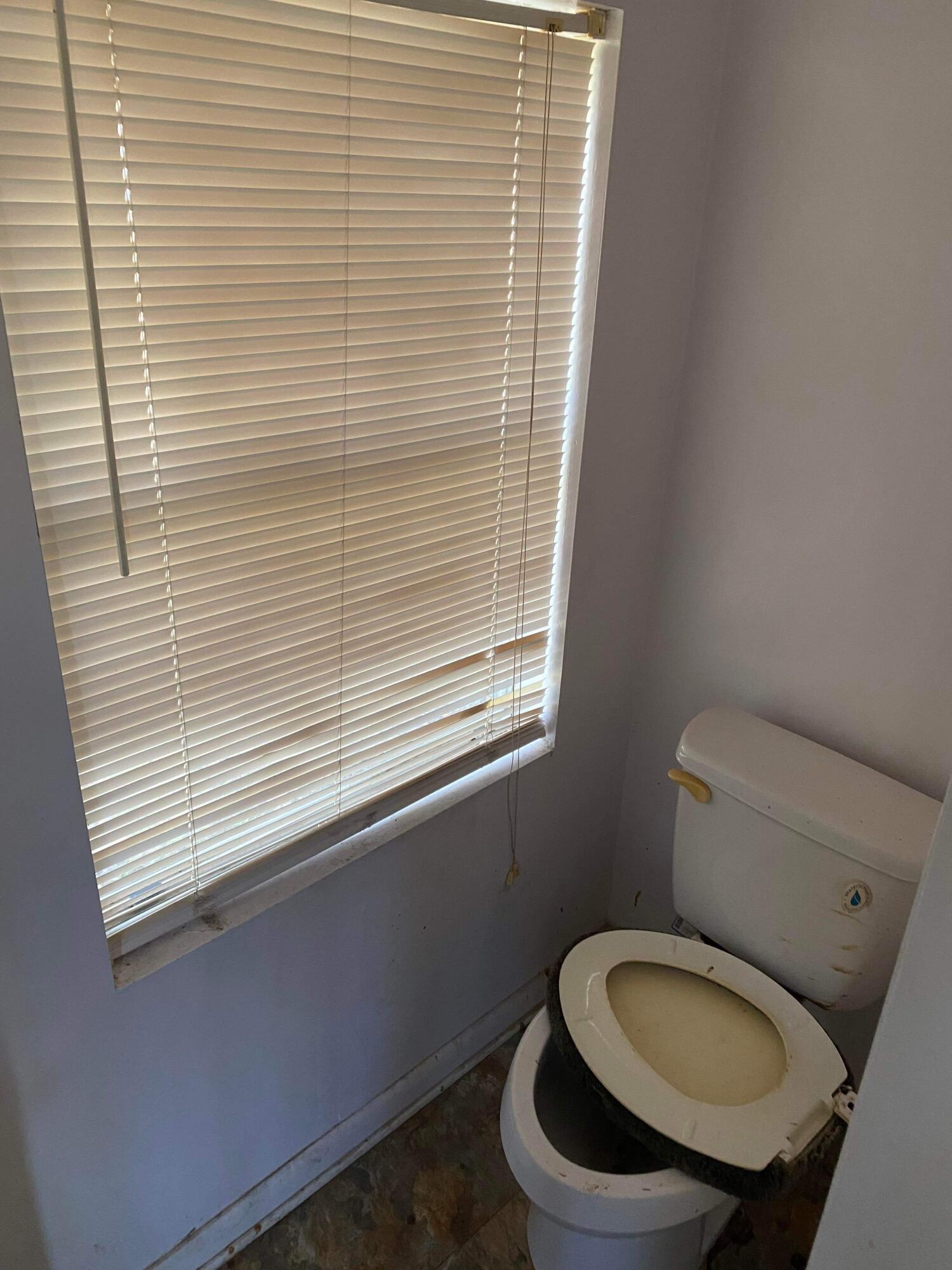 145 Live Oak Avenue West DeFuniak Springs, FL 32435 - Photo 16 of 25 a toilet sitting in a bathroom next to a window