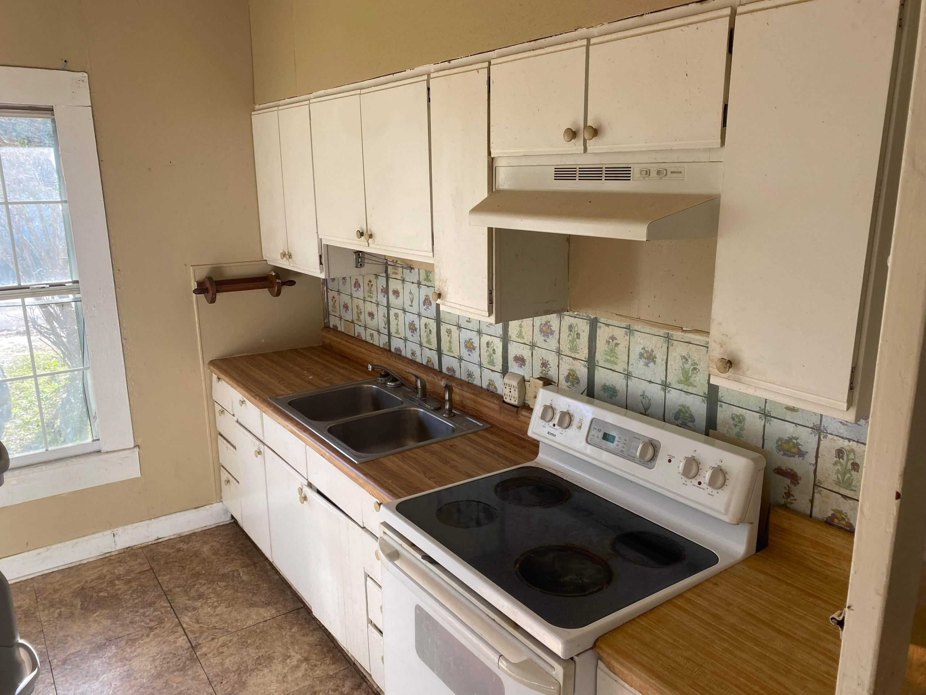 145 Live Oak Avenue West DeFuniak Springs, FL 32435 - Photo 4 of 25 a kitchen with a stove and a sink