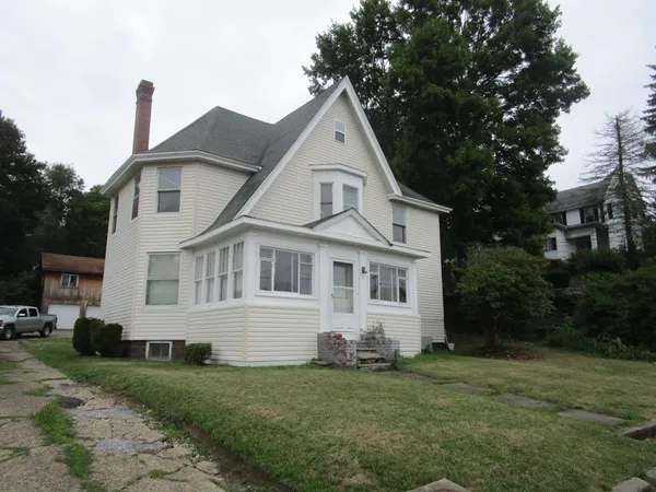 a front view of a house with a garden