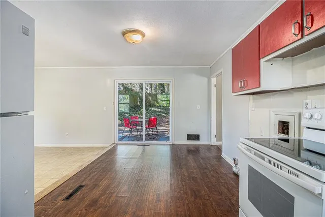 an empty room with wooden floor and fan