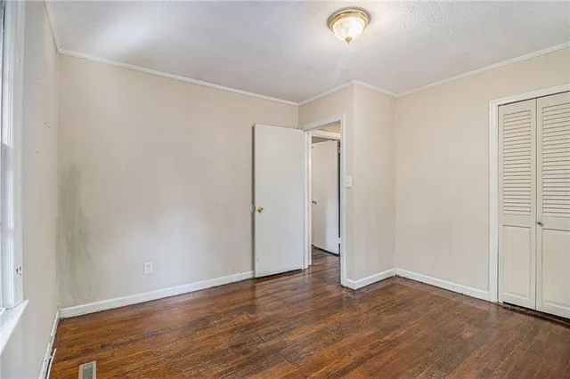 a view of an empty room with wooden floor