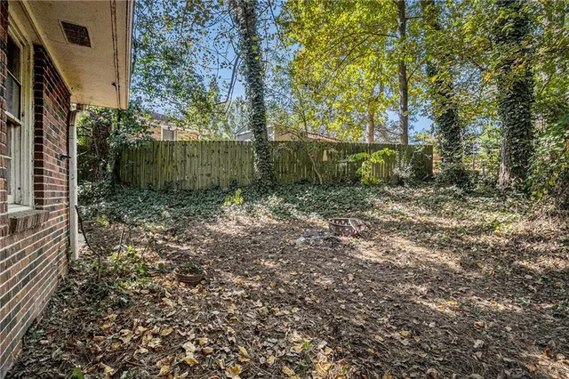 a view of a yard with large trees and plants