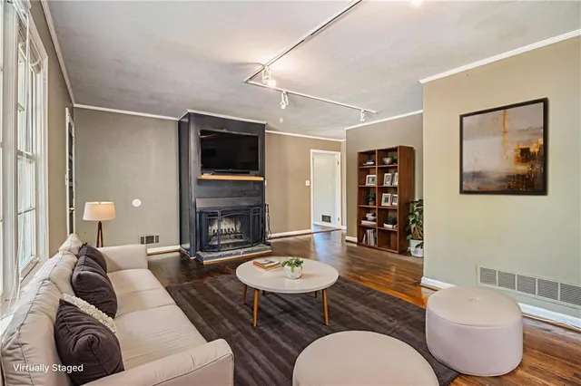 a living room with furniture a flat screen tv and a fireplace