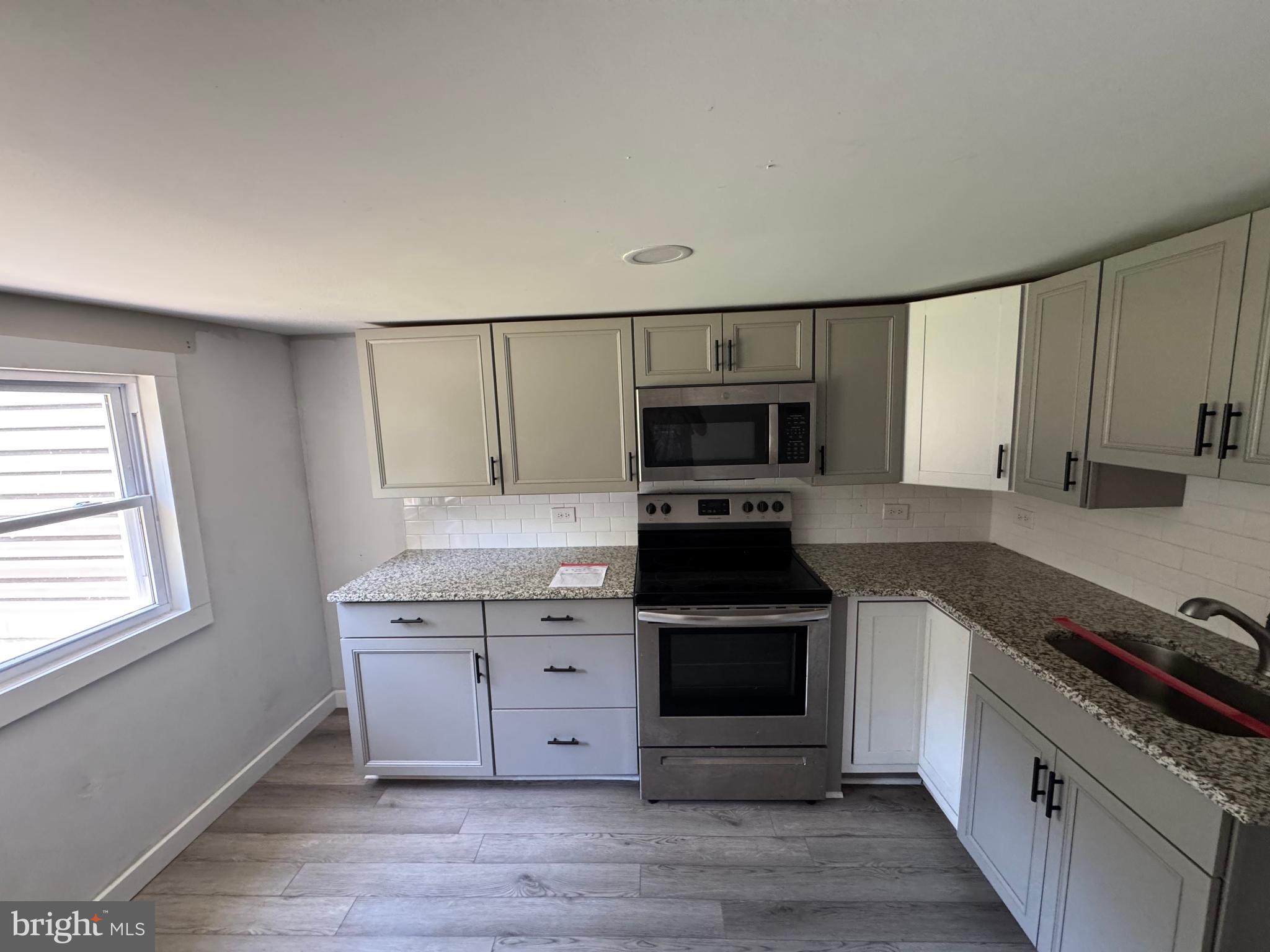 395 Tansboro Road Berlin, NJ 08009 - Photo 17 of 47 a kitchen with stainless steel appliances a stove sink and cabinets