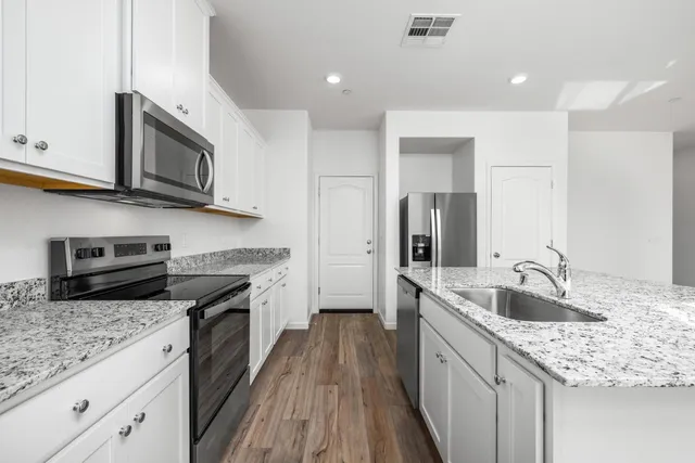 a kitchen with stainless steel appliances granite countertop a sink stove microwave and cabinets