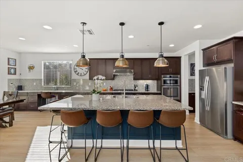 a kitchen with stainless steel appliances granite countertop a kitchen island a stove and a cabinets