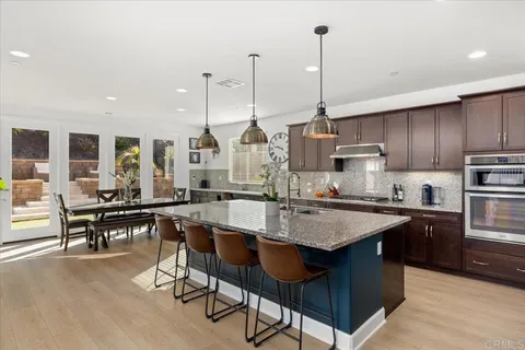 a kitchen with stainless steel appliances granite countertop a stove top oven and a sink