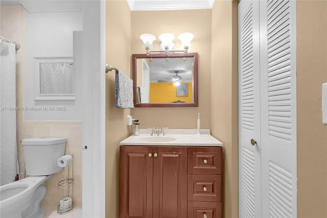 a bathroom with a toilet sink vanity and mirror