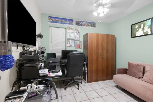 a view of a workspace with furniture and a flat screen tv