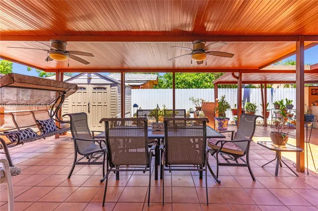 a view of a patio with a table and chairs under an umbrella