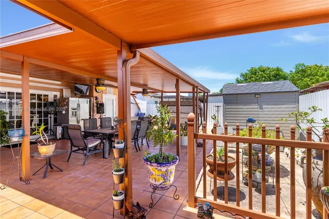 a view of a patio with dining table and chairs under an umbrella