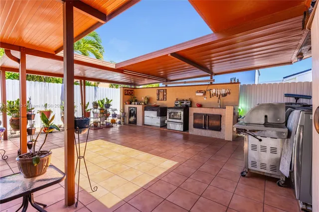 a view of a patio with a table and chairs under an umbrella