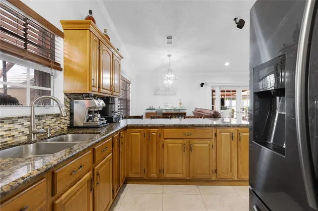 a kitchen with stainless steel appliances granite countertop a sink a stove and a refrigerator