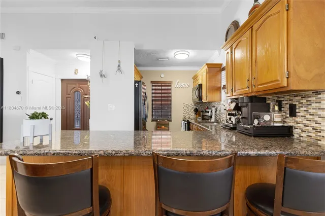 a kitchen with kitchen island granite countertop a sink stove and cabinets
