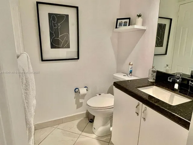 a kitchen with a sink a kitchen island a stove and a refrigerator