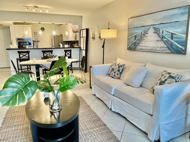 a living room with furniture a flat screen tv and a potted plant