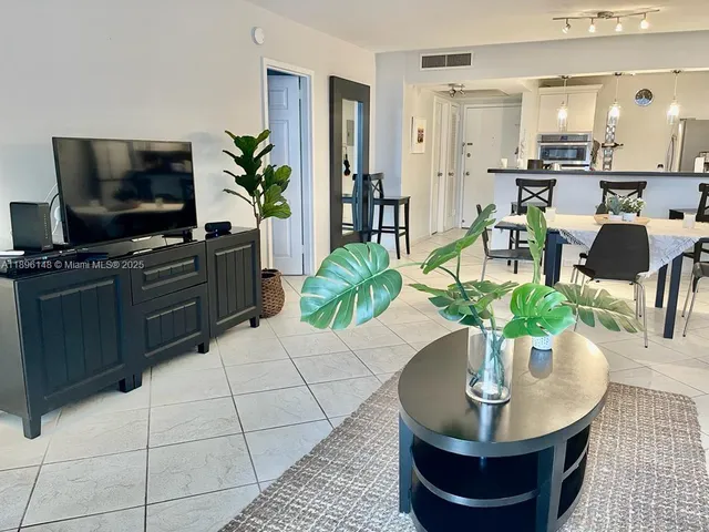 a living room with furniture kitchen and a table