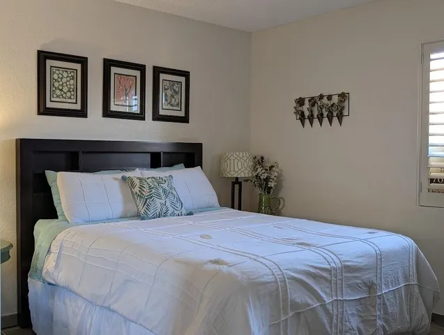a bedroom with a large bed and a potted plant